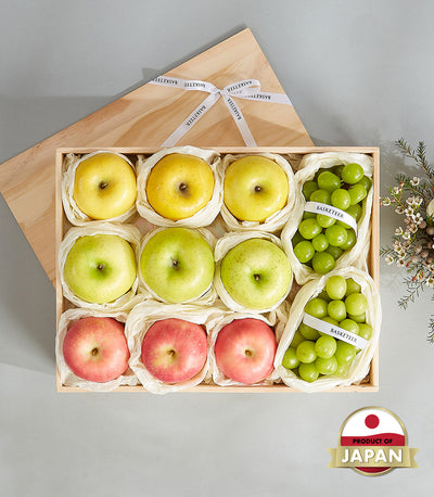 Premium Japanese fruit gift box with yellow, green, and red apples and green grapes in wooden presentation case