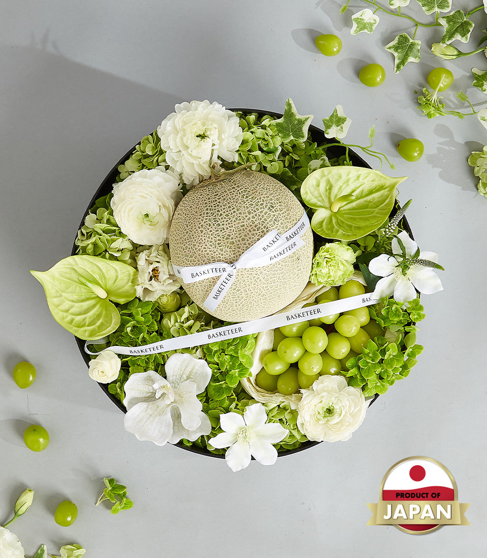 Premium Japanese cantaloupe and grape gift box with white flowers in dark round container