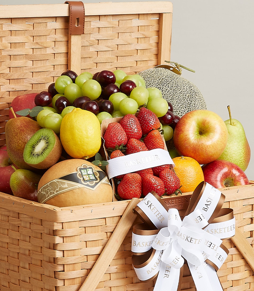 Premium woven fruit gift basket with fresh grapes, strawberries, apples, kiwi, and melon for celebrations or thank you