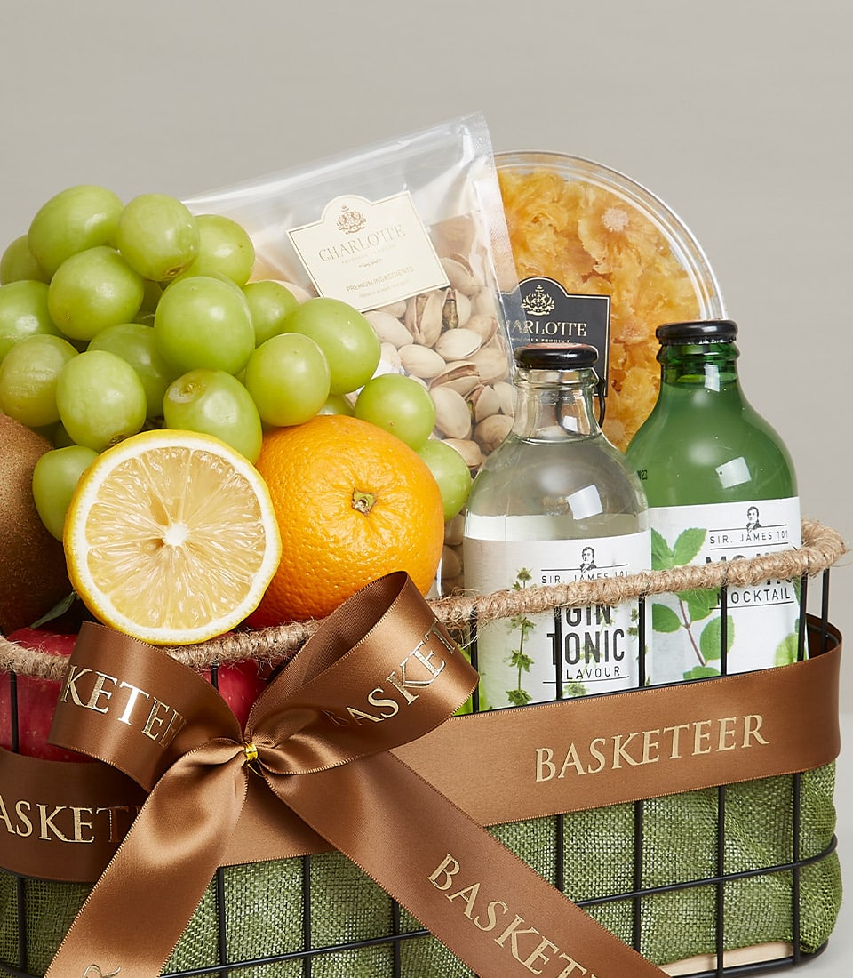 Black wire mesh wellness fruit basket with fresh citrus, grapes, kiwi, premium nuts, and artisan snacks