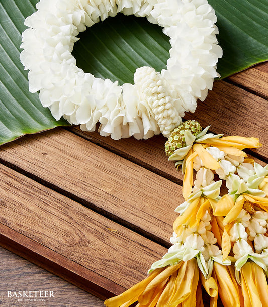 Fragrant white jasmine phuang malai garland with yellow tassel on banana leaf, traditional Thai New Year gift