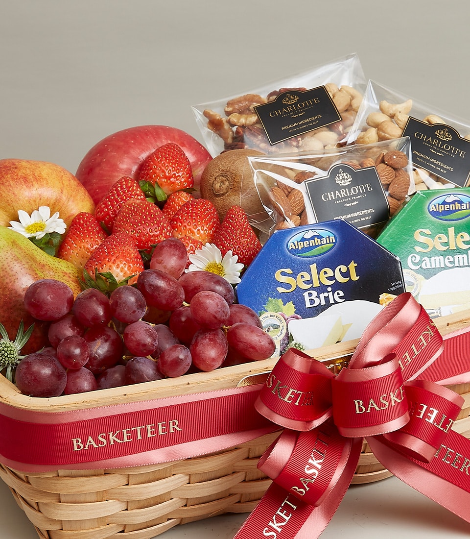 Luxury fruit, cheese and nut gift basket with fresh strawberries, apples, grapes, gourmet cheeses and roasted nuts