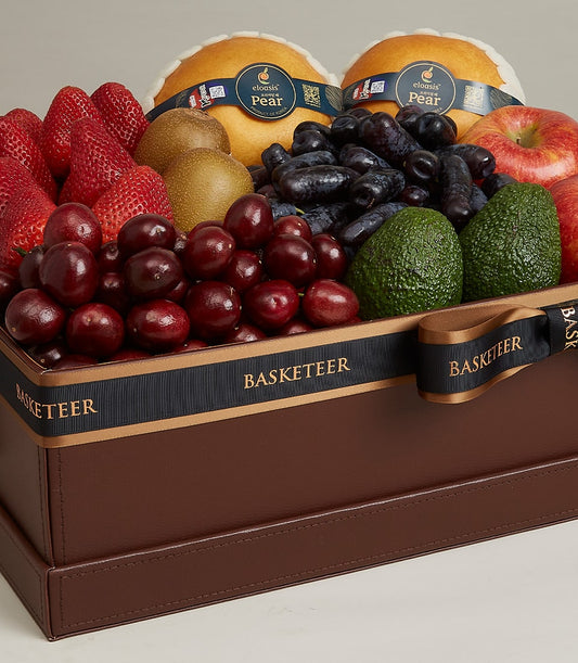 Basketeer luxury gift basket Bangkok, featuring strawberries, Asian pears, cherries, and avocados in a leather-style box with a black ribbon.