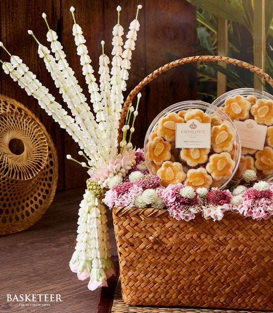 Songkran gift basket with almond flower cookies, fresh pink and white roses, and traditional floral garland