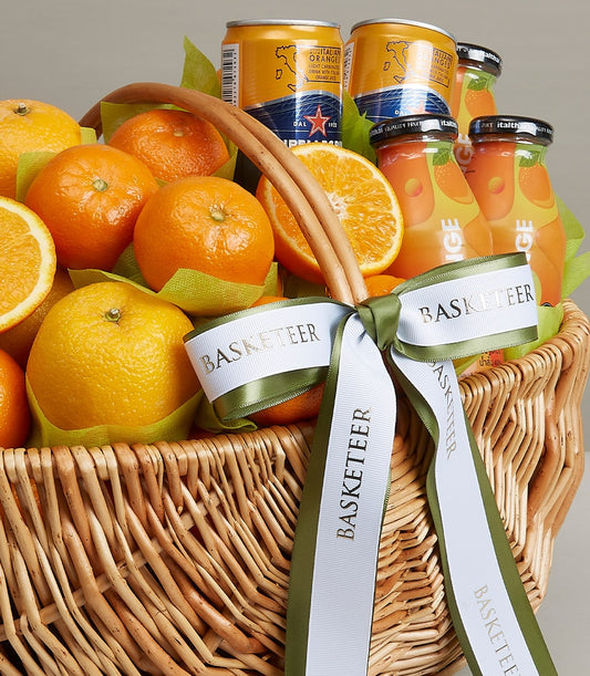 Orange Extravaganza wicker hamper with fresh oranges, citrus beverages, and orange juice in luxury gift basket