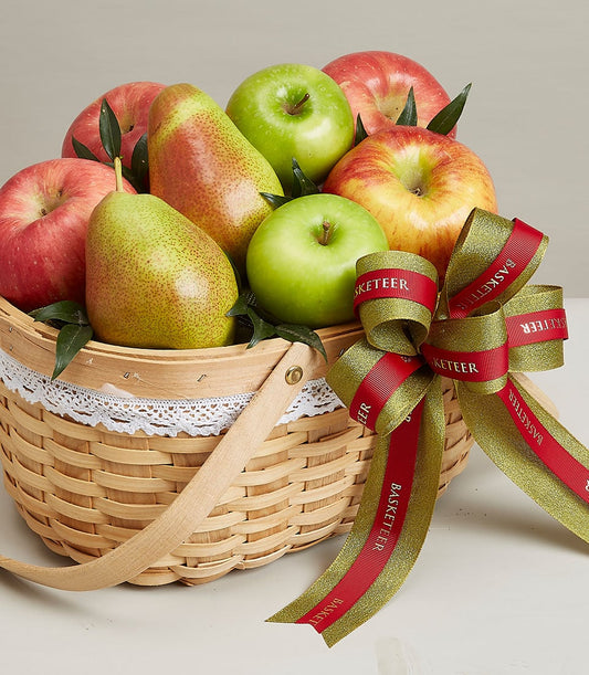 Light woven wood fruit basket with red and green apples, pears, and gold-red ribbon bow