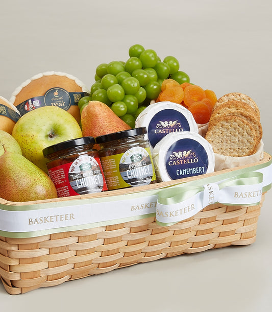 Woven gift basket with fresh pears, grapes, green apple, artisan cheeses, chutneys, and crackers
