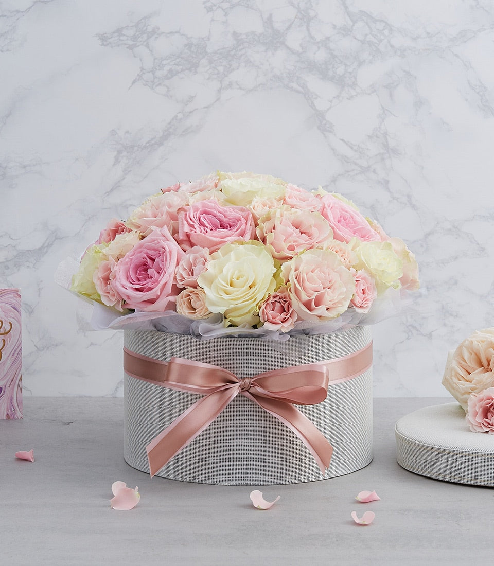 Pastel pink and cream roses in light grey hatbox with rose gold ribbon