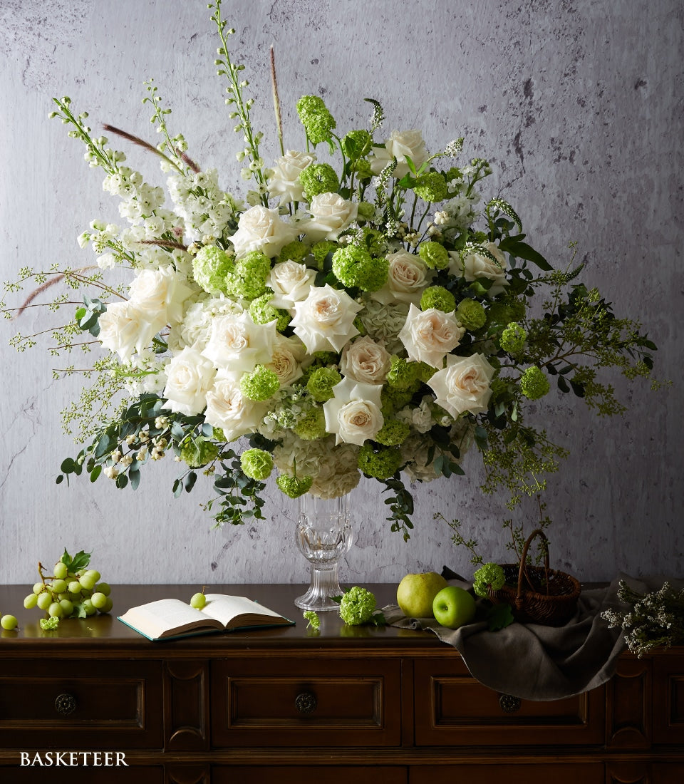 White and light pink roses with button chrysanthemums in clear glass vase, elegant floral arrangement for celebrations and