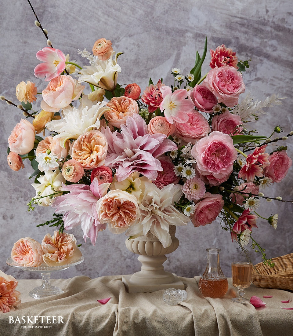 Classic urn vase with pink, peach and white roses, dahlias and ranunculus arrangement for congratulations and new home