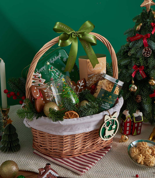 Deluxe Christmas gift basket with butter cookies, Lindor chocolates, gingerbread, and festive gold baubles in woven wicker