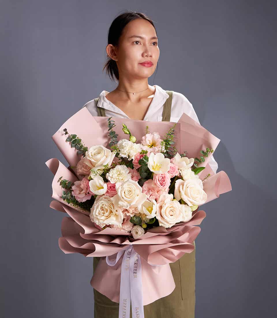 Ivory and blush rose bouquet with white tulips wrapped in soft pink paper and white ribbon