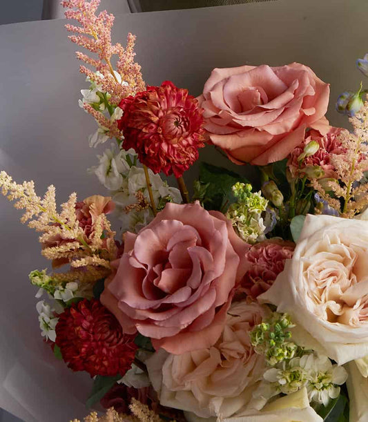 Ivory roses and blue delphiniums with peach astilbe in a premium fresh flower bouquet