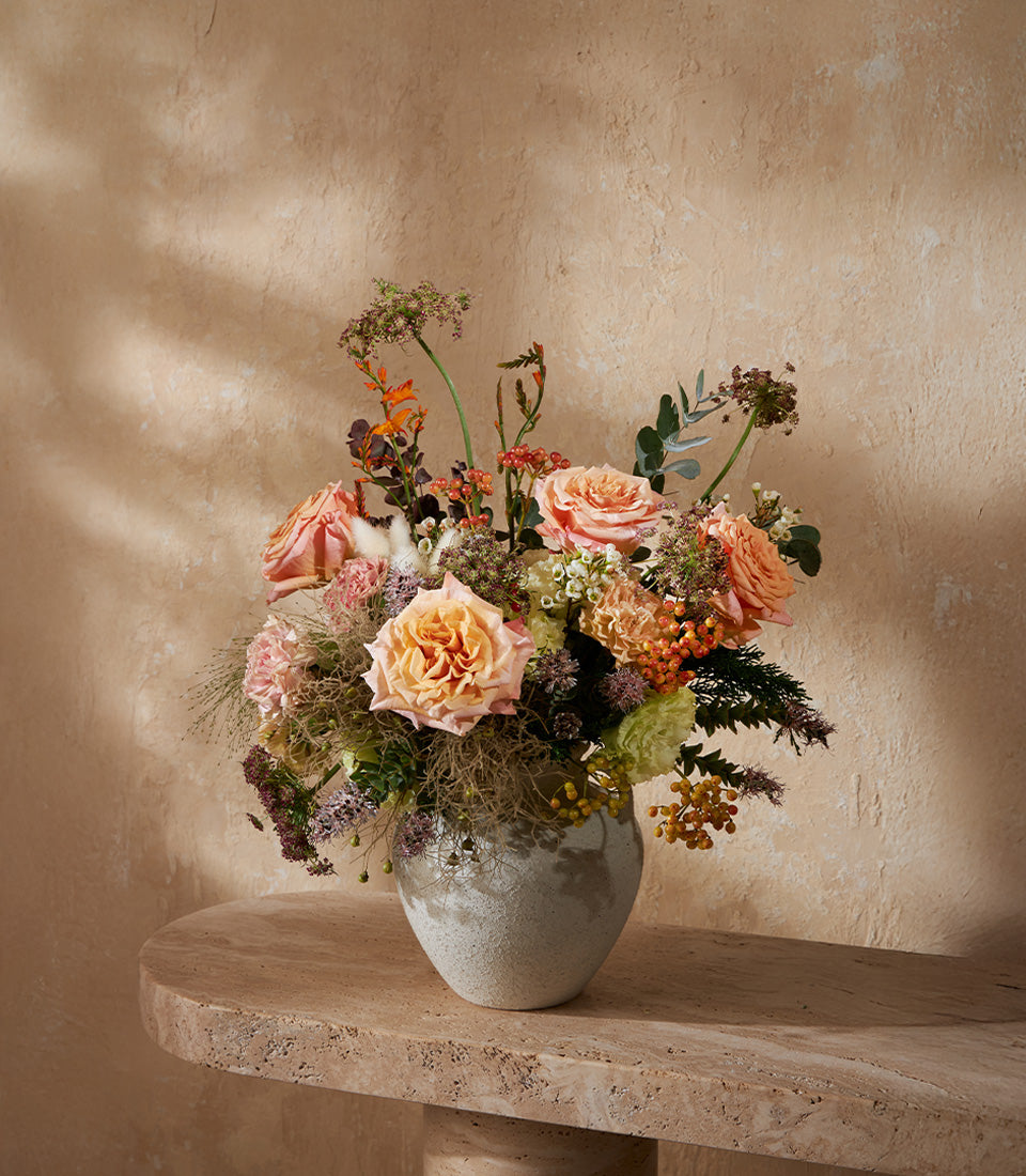 Peach and orange roses with pink blossoms in grey ceramic vase, luxury floral arrangement for gifting