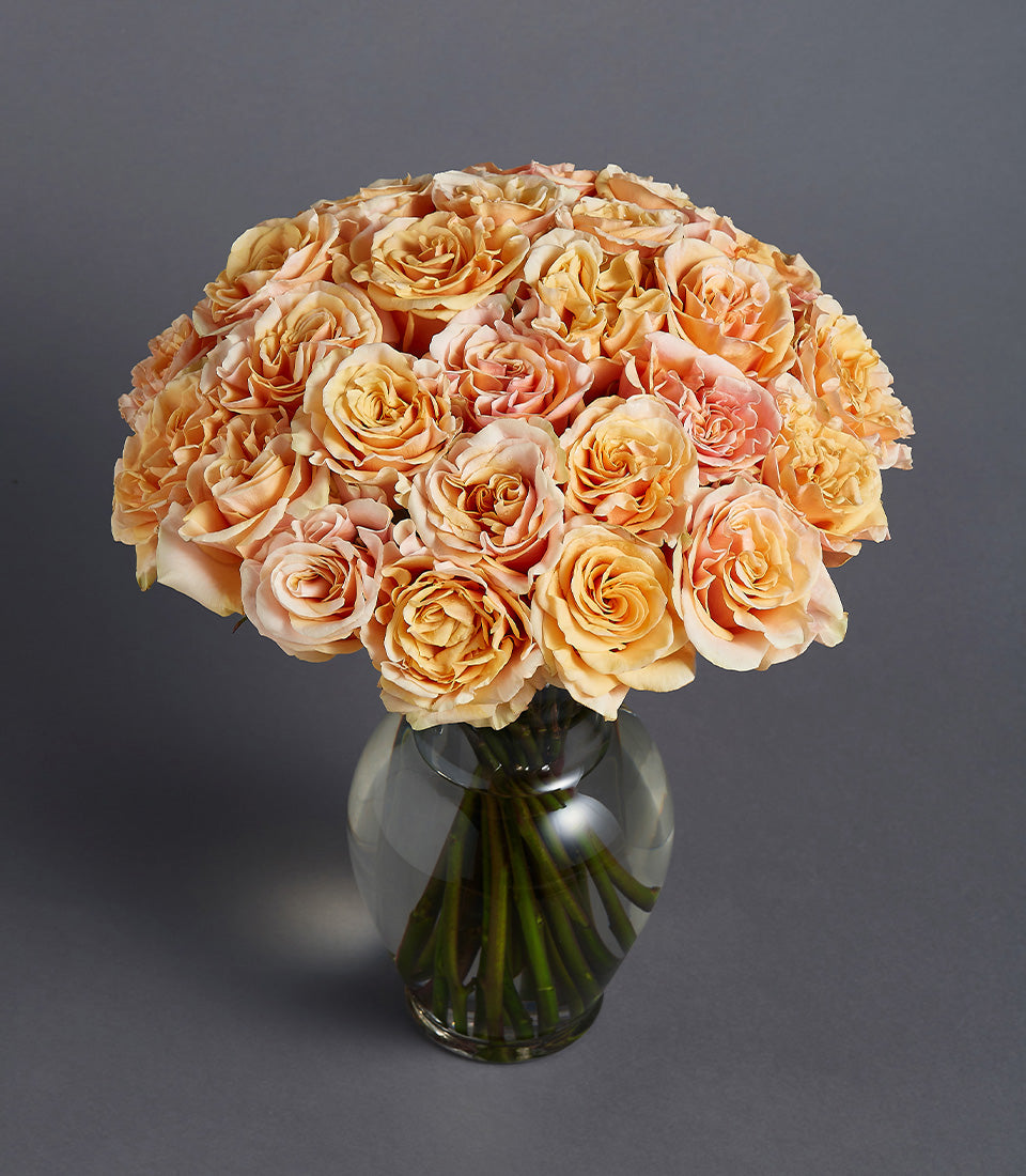 Peach and orange rose bouquet in glass vase, perfect for birthday and celebration gifts
