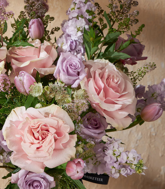 Pink and lavender roses with tulips in fresh vase arrangement, luxury gift hamper with ribbon detail