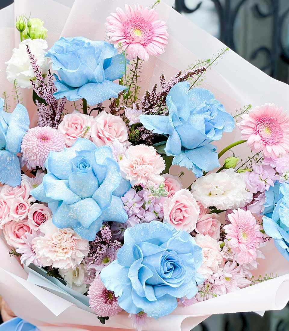 Blue and pink fresh flower bouquet with roses, gerberas, and white eustoma for birthday celebrations