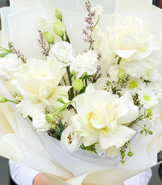 White roses and mixed blooms graduation bouquet with cream wrapping, elegant fresh flower arrangement