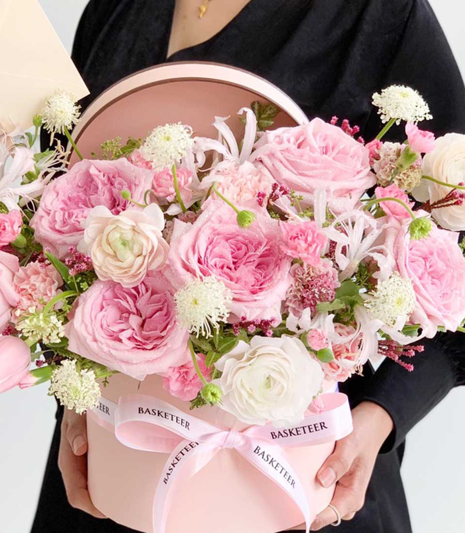 Pink roses and ranunculus in luxury gift box with ribbon, perfect for birthday or romantic occasions