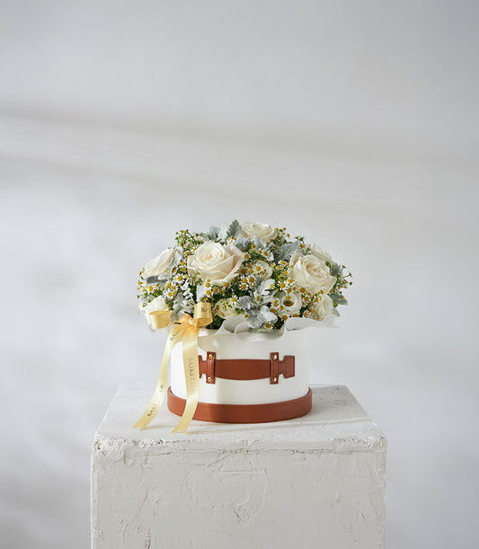 White roses and daisy flowers in luxury leather hatbox with golden ribbon bow