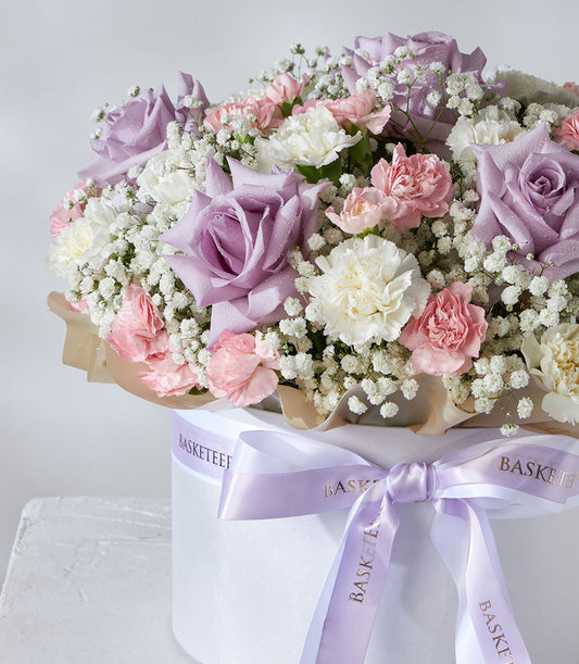 Lavender roses and pastel carnations in white luxury flower box with satin ribbon