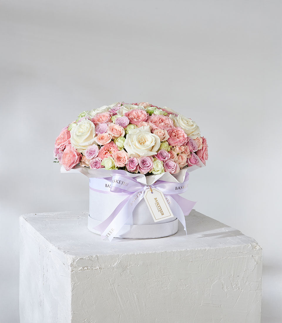 White hatbox with luxury Playa Blanca roses in white, blush, and lavender with spray roses and greenery