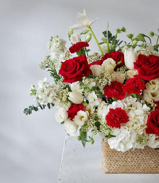 Red roses and white hydrangea arrangement in natural woven basket, premium fresh flowers for gifting