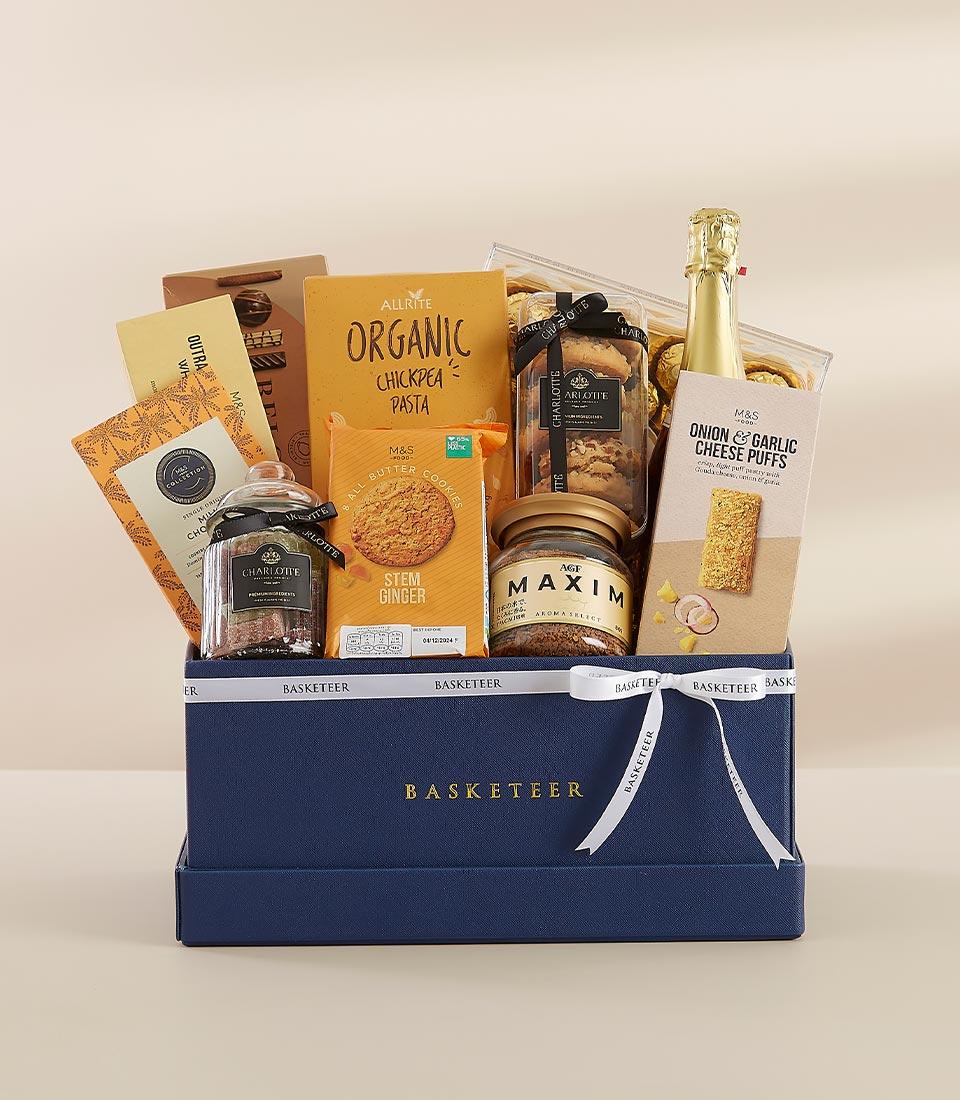 Dark blue luxury gift hamper with gold Basketeer branding, champagne, gourmet treats and artisan food selections