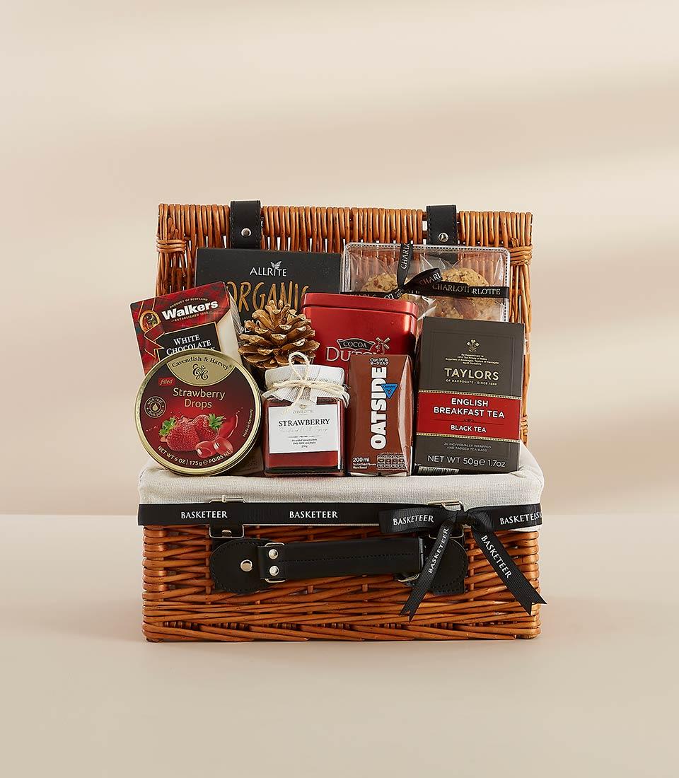 Premium wicker gift hamper with gourmet treats, black ribbon, and New Year gifting essentials