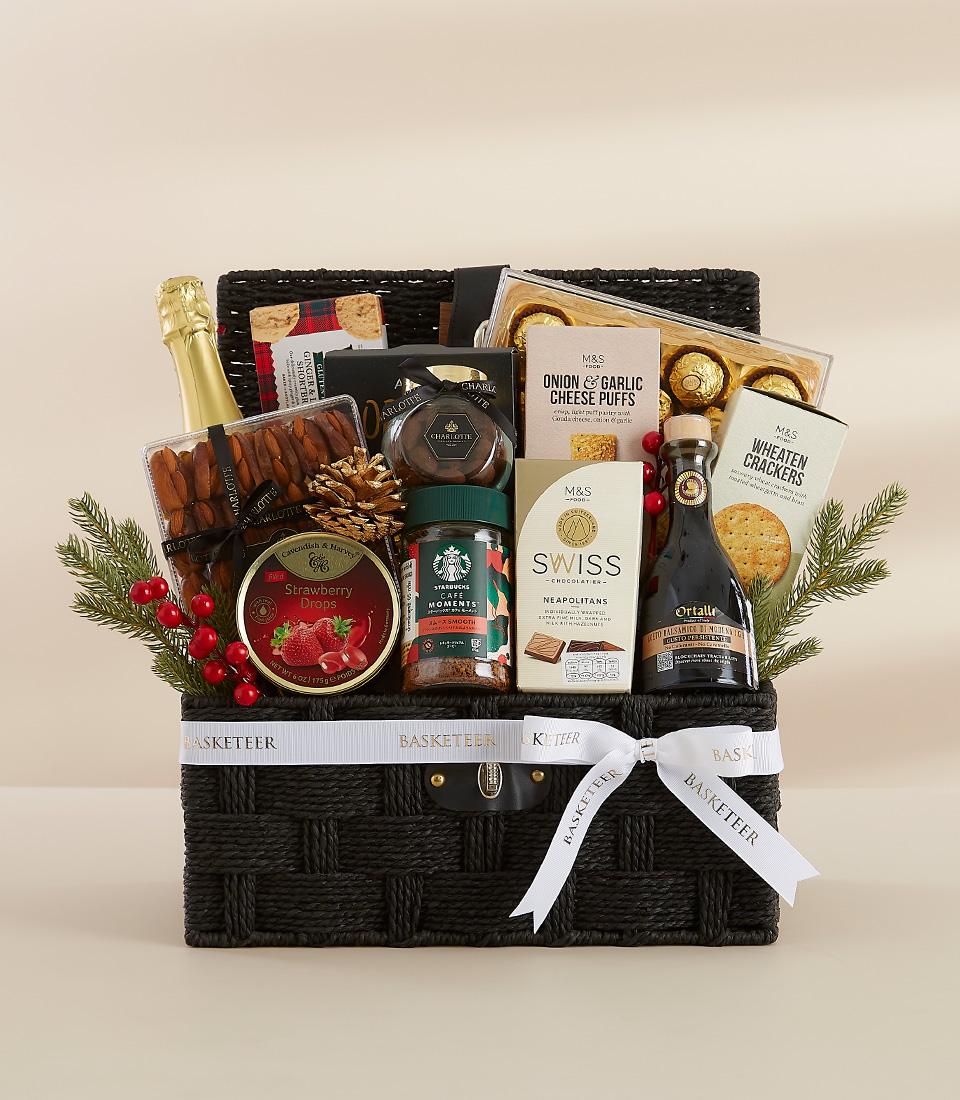Premium Christmas gourmet gift basket with champagne, artisan chocolates, and festive treats in dark woven basket