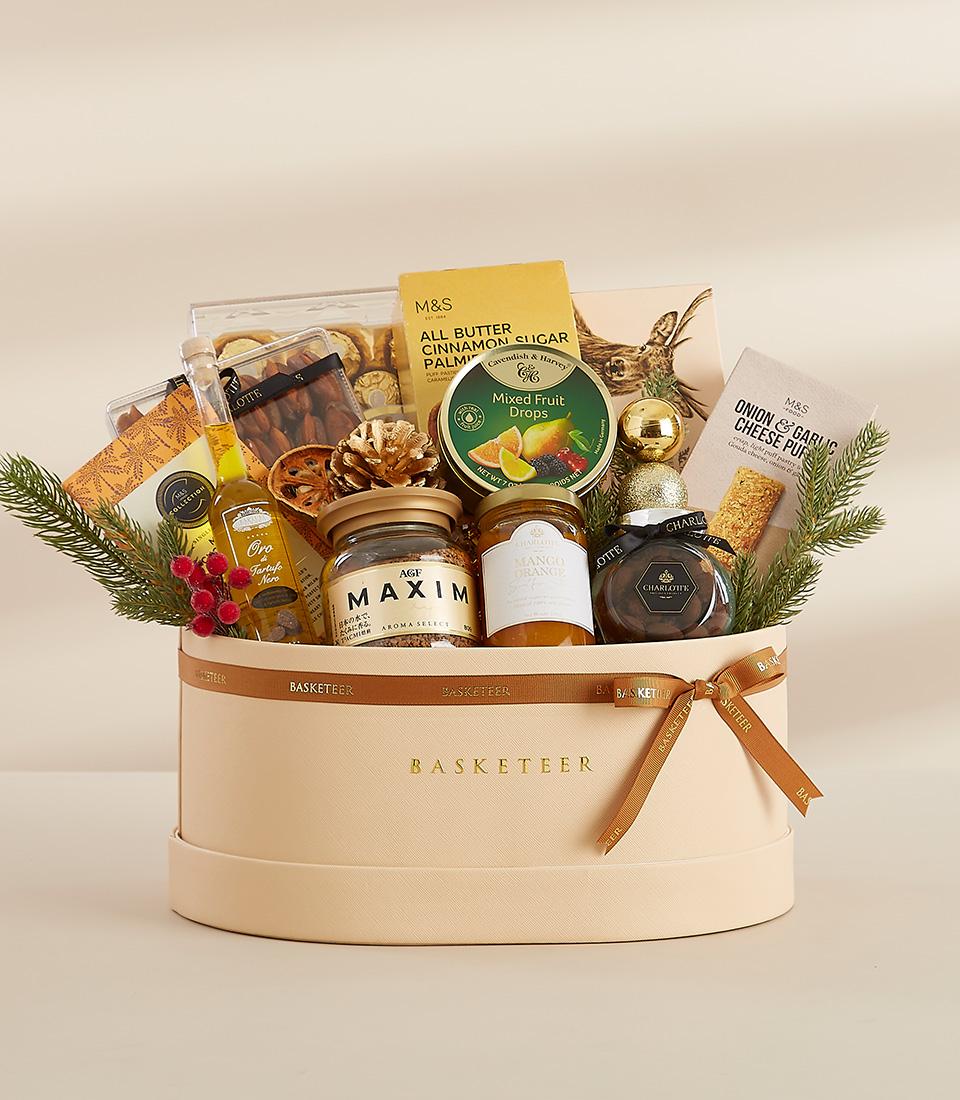 Gilded Gatherings luxury gift box with gourmet foods, coffee, jam, and truffle oil in beige leather basket with gold bow