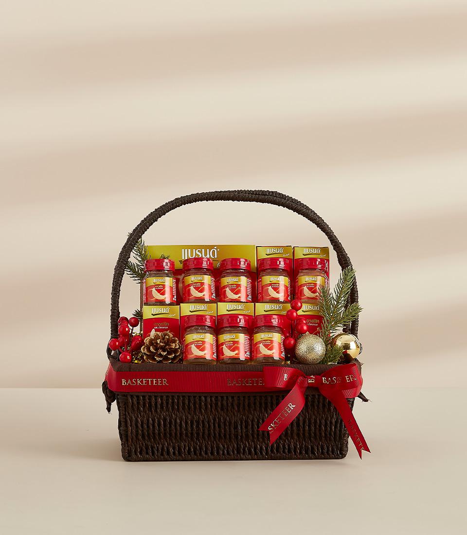 Premium wellness gift hamper with bird's nest jars, yellow boxes, and festive holiday decor in woven basket