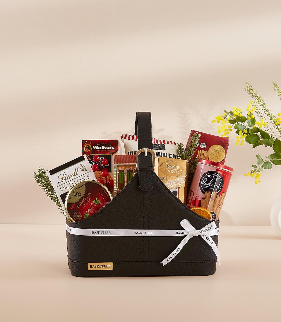 Basketeer premium hamper delivery Thailand: Elegant gift basket with Lindt chocolate, Walkers shortbread, and wafer rolls. White ribbon wrap.