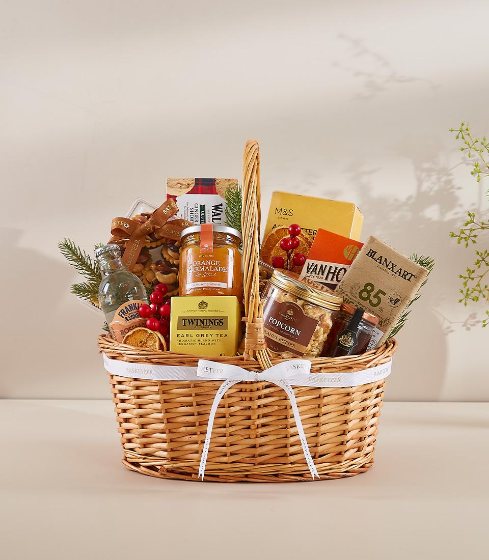 Woven wicker gourmet gift hamper with marmalade, Earl Grey tea, chocolate, and festive dried fruit for New Year