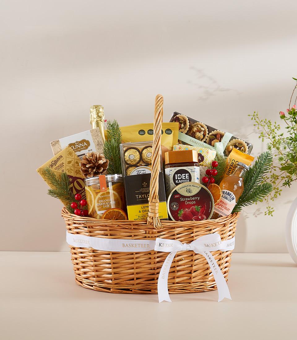 Premium wicker gift basket with champagne, chocolates, gourmet jams, and festive holiday treats for New Year gifting