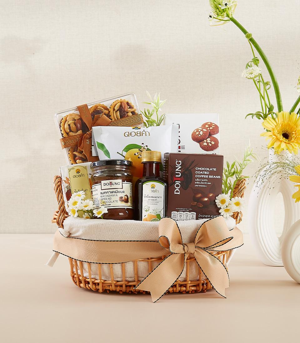 Wicker gift basket with macadamia spread, coffee beans, pastries, and flowers for New Year wellness gifting