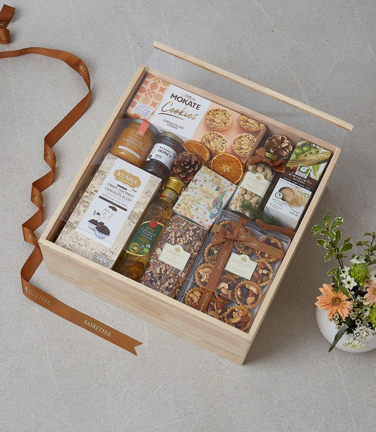 Premium gourmet gift basket with cookies, honey, marmalade, and artisan treats in wooden box with flowers