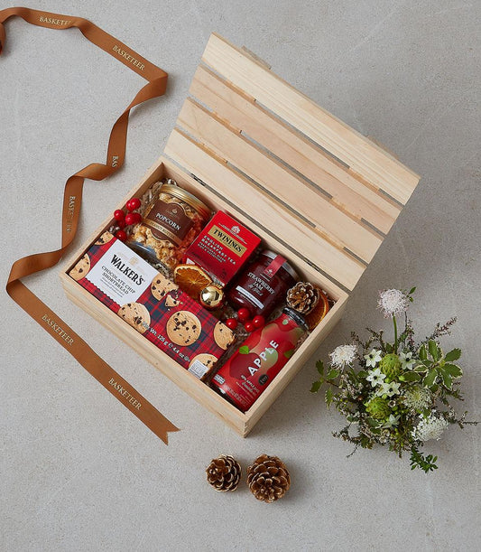 Luxe wooden crate gift hamper with gourmet treats, jam, tea, and festive red accents