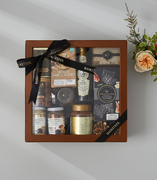 Luxury gourmet hamper with chocolate, crackers, truffle spreads, and honeycomb in brown gift box with Basketeer ribbon