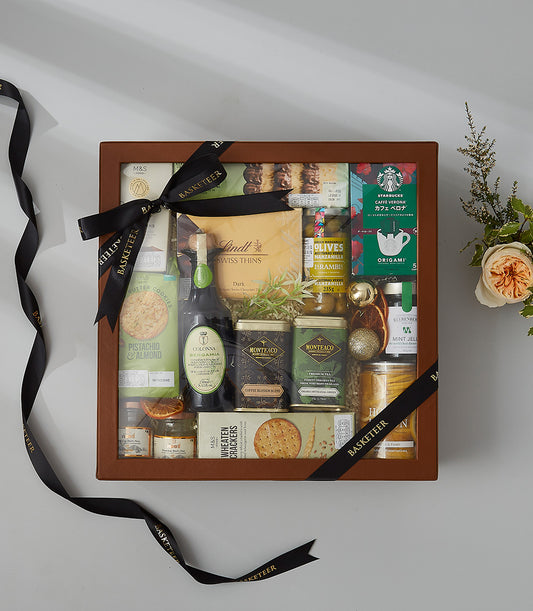 Deluxe gourmet gift hamper with chocolate, coffee, preserves, and peach rose bouquet in dark wood box