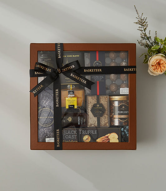 Black gourmet gift hamper with Italian truffle toast, honey, and artisan crackers in luxury presentation box