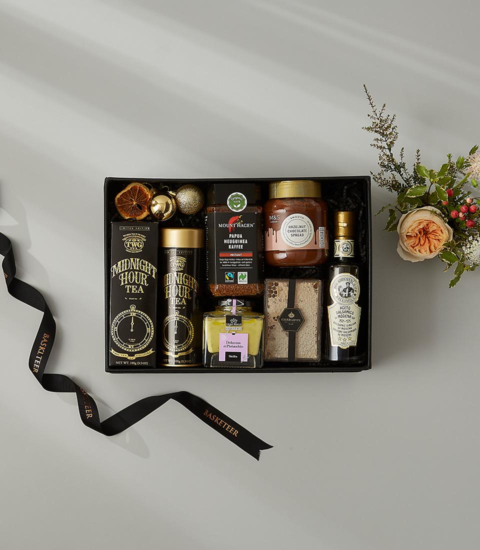 Luxury black gift box with Midnight Hour Tea, gourmet spreads, coffee, and honeycomb, accented with gold details and peach
