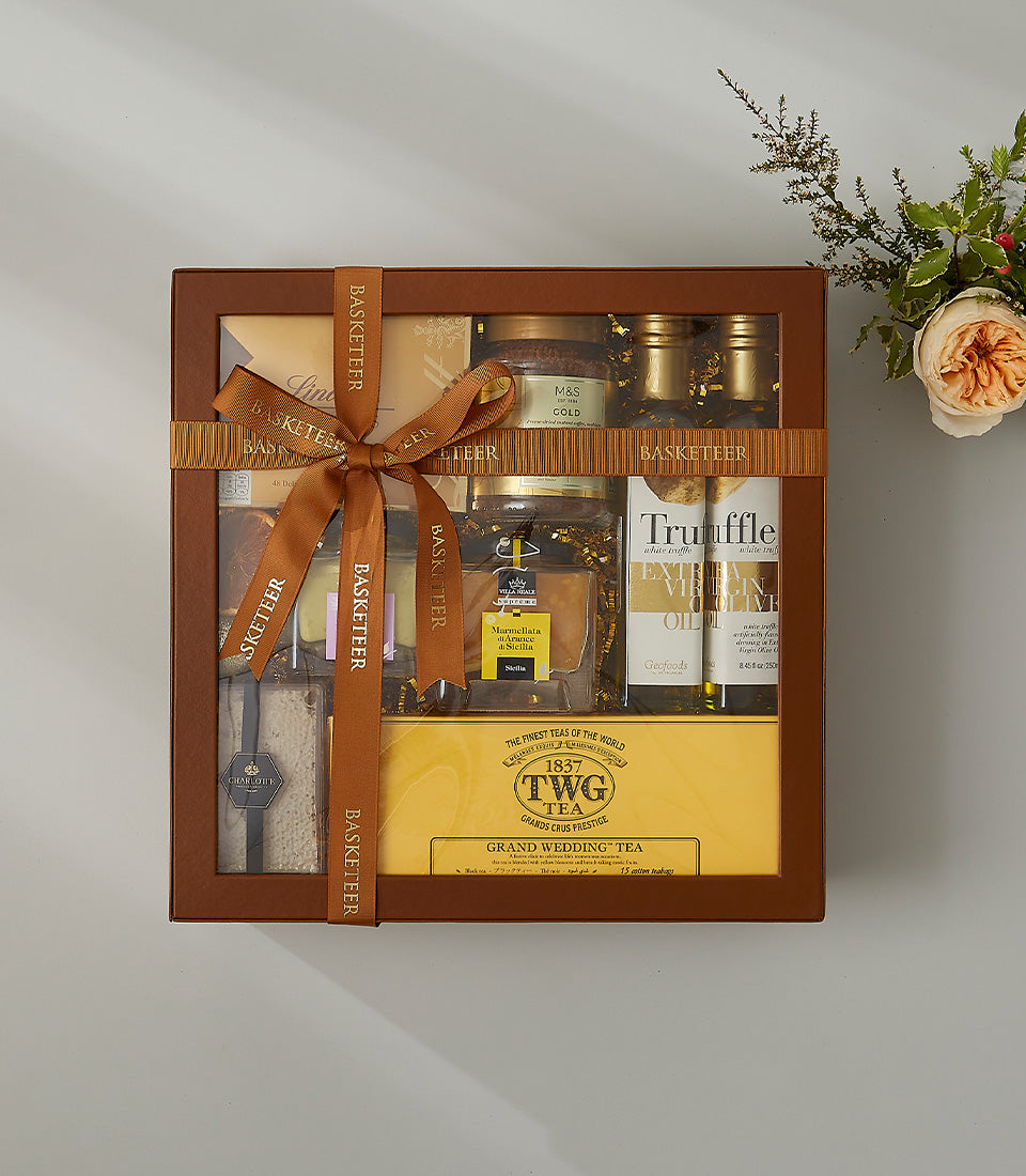 Luxury gourmet hamper with Sicilian marmalade, truffle olive oil, and premium tea in brown leather box with satin ribbon