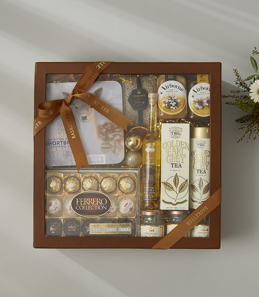 Luxury gourmet gift box with Earl Grey tea, honey, artisan chocolates, and golden accents