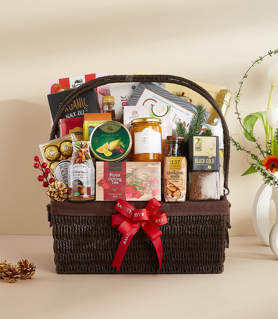 Dark woven wicker basket with gourmet wellness gifts, tea, chocolates, and coffee for New Year celebration