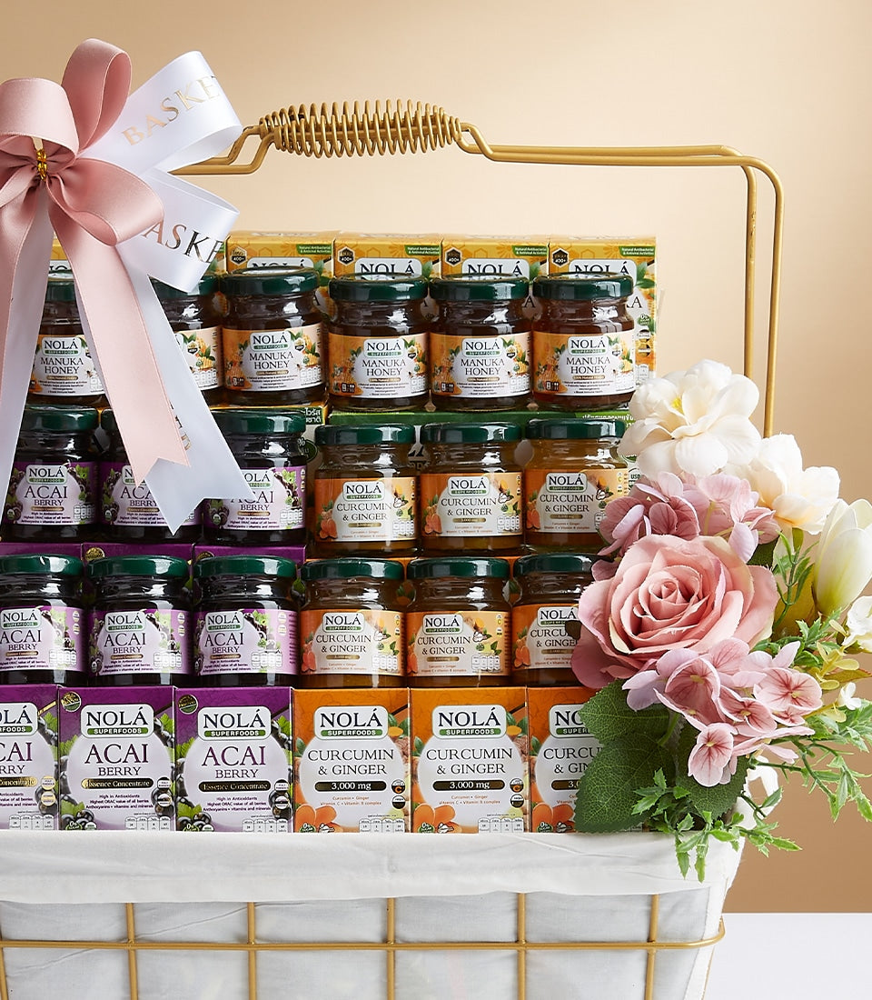 Nola's mixed collection gift basket with manuka honey, acai berry, and curcumin supplements in white woven basket with pink