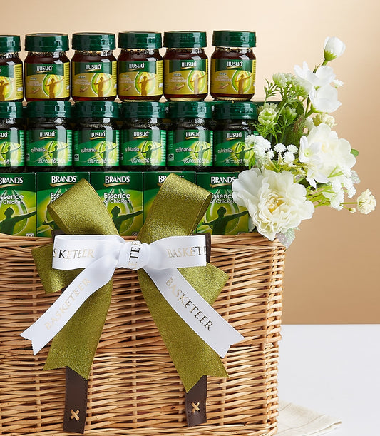 Premium chicken essence and wellness gift basket with glass bottles, green boxes, and white florals in woven wicker