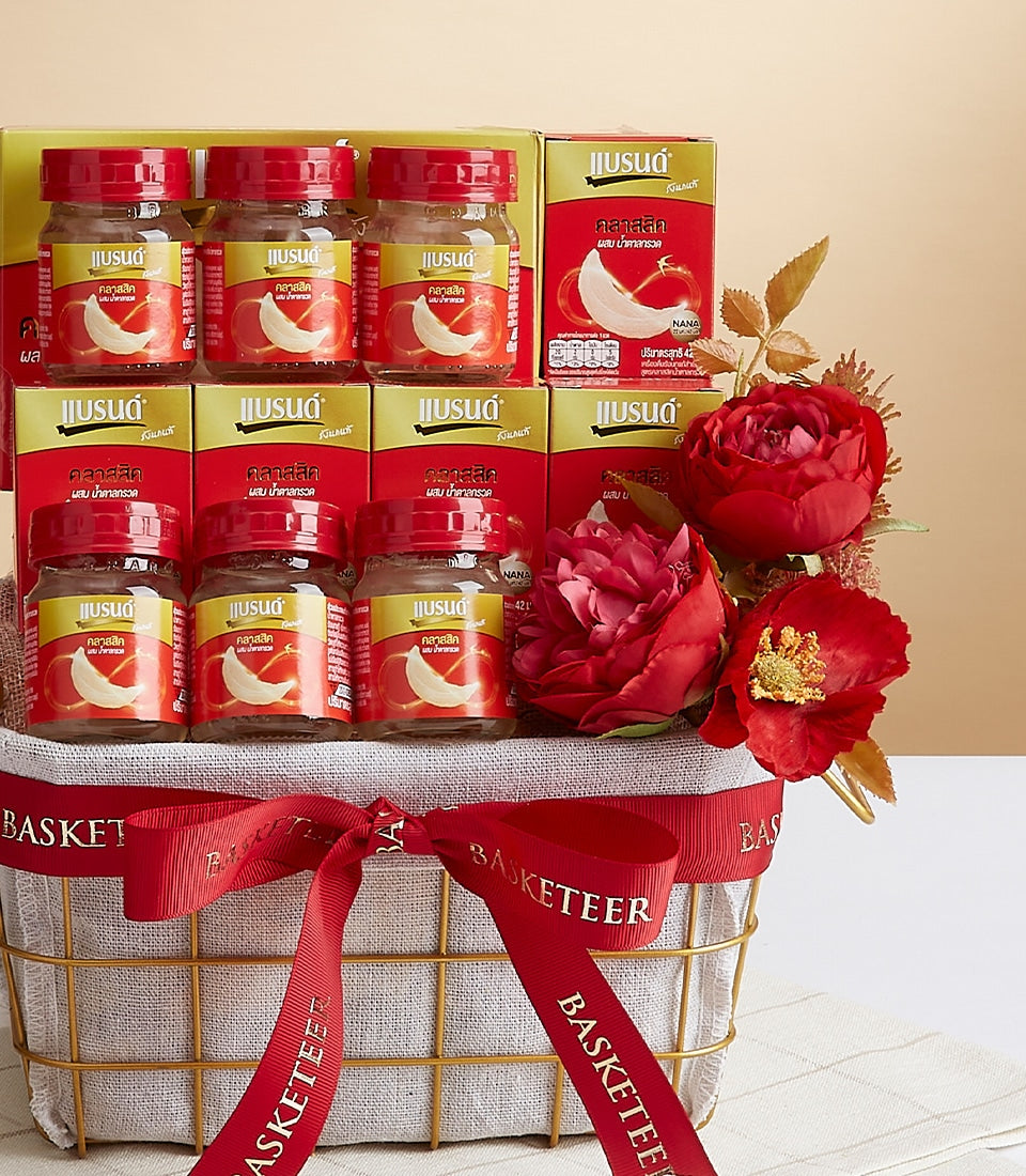 Premium bird's nest wellness gift basket with twelve glass jars, gold wire frame, red satin ribbon bow