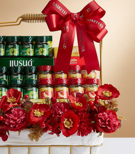 Premium mixed beverage gift basket with red ribbon, glass bottles, and red flowers on gold-trimmed white basket
