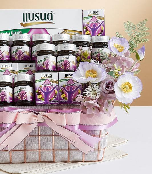 Rose gold wire mesh gift basket with plum health supplements, grey lining, pink lavender ribbon bow, and white flower